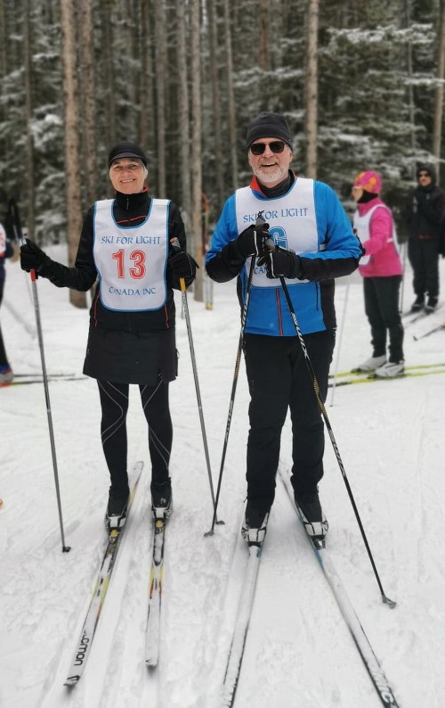 Jeff and Liz, Woman and Man with Cross Country Skis wearing Ski For Light Canada Bibs Woman and Man with Cross Country Skis wearing Ski For Light Canada Bibs